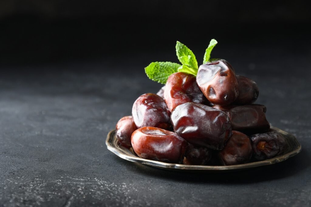 Ramadan kareem. Dates fruits in bowl on black. Close up